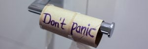 An empty roll of toiler paper with the text 'Don't panic' written in ballpoint pen