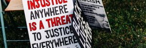 signs placed on grass leaning on a chair. text on the signs reads: INJUSTICE ANYWHERE IS A THREAT TO JUSTICE EVERYWHERE Dr. Martin Luther King Jr. BLACK LIVES MATTER Warning Signs of FASCISM SILENCE IN THE FACE OF EVIL IS ITSELF EVIL: GOD WILL NOT HOLD US GUILTLESS